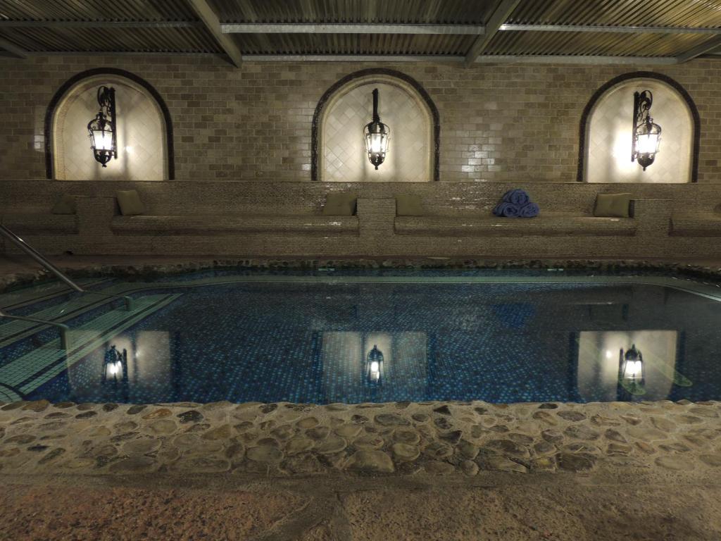 沙漠温泉托斯卡纳温泉水疗酒店的一座带三盏灯的建筑中的游泳池
