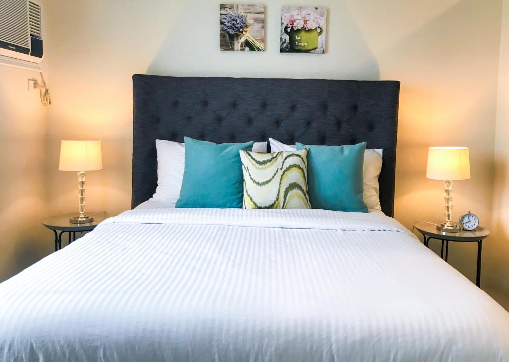 宿务One Bedroom Apartment at Sundance Residences with Hi-Speed WiFi的卧室配有带蓝色枕头的大型白色床