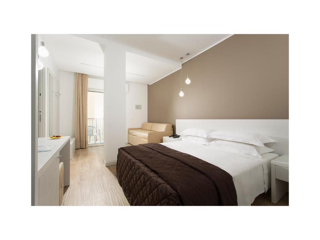 利多迪耶索罗栀子酒店的卧室配有一张白色大床和一张书桌