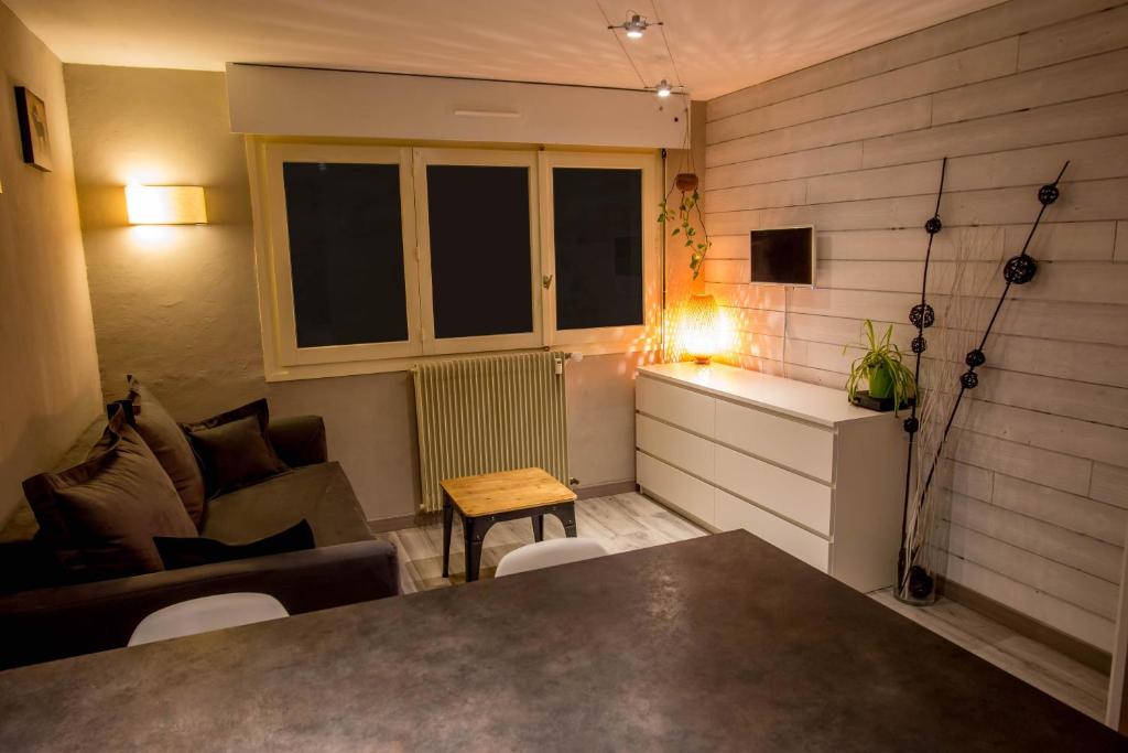 拉克吕萨Studio Belmont - Centre village la Clusaz - AravisTour的带沙发和桌子的小客厅