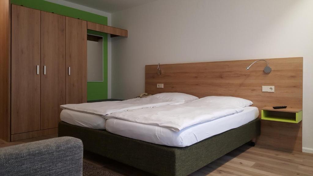 弗莱堡鲁艾 - 禁烟旅馆的一间卧室配有一张大床和木制床头板