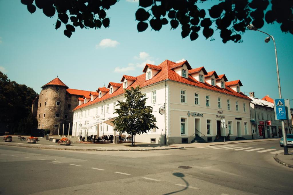 奥古林Heritage Hotel Frankopan的一座白色的建筑,有红色的屋顶和城堡