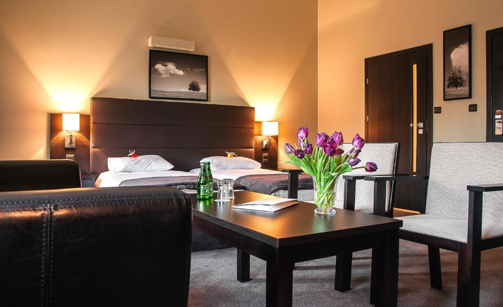 卢布林宜兰酒店的配有床和鲜花桌的酒店客房