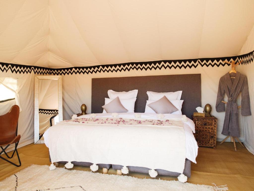 El GoueraNubia Luxury Camp Erg Chegaga的帐篷内一间卧室,配有一张大床