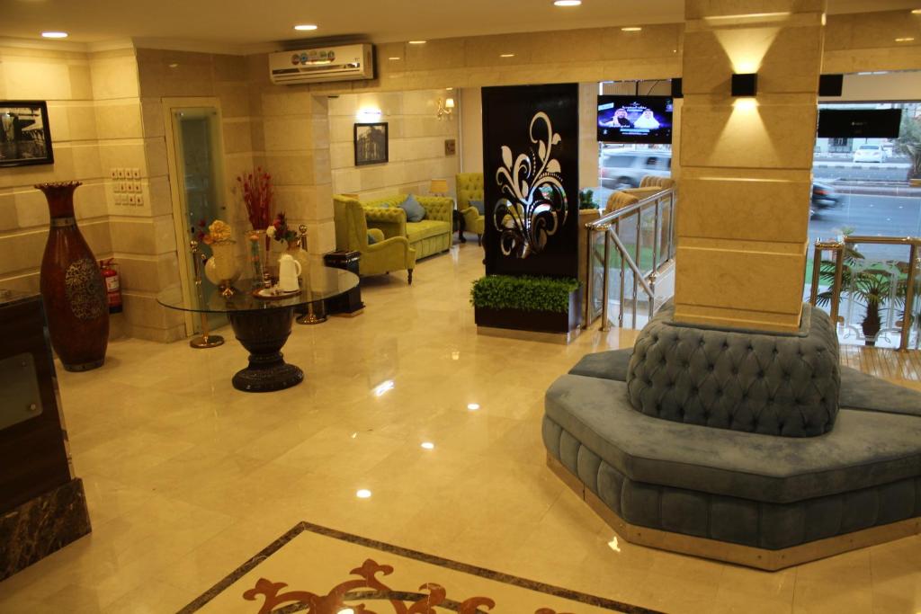 麦地那Al Mokhmalia Residential Units的大楼内一个带沙发和桌子的大堂