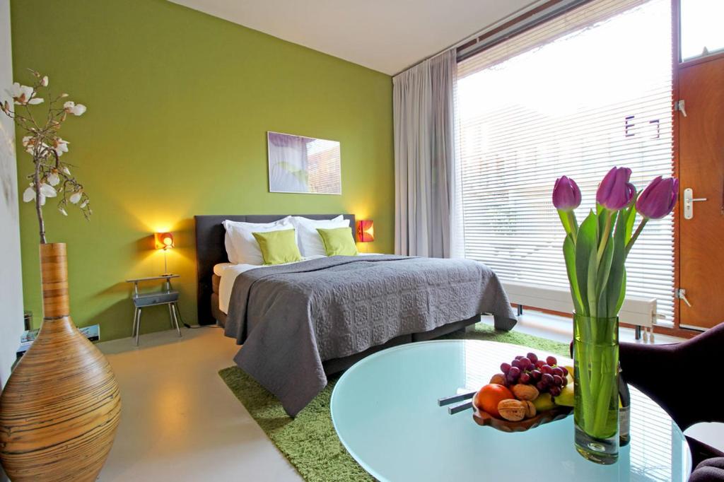阿姆斯特丹东梦住宿加早餐旅馆的一间卧室配有一张床和一张鲜花桌