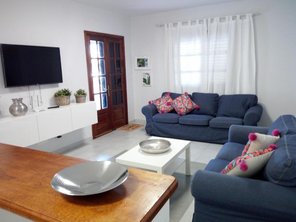 宏达海滩Apartamento playa coqueto junto al mar的客厅配有2张蓝色的沙发和1张桌子