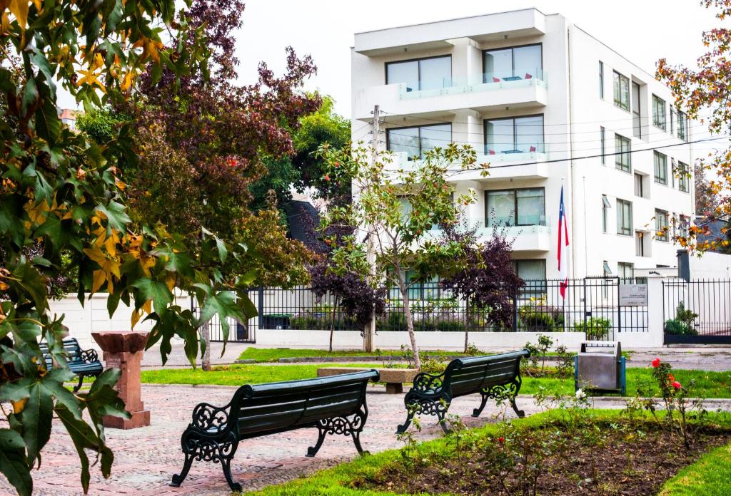 圣地亚哥海德堡豪斯公寓酒店的两长椅,在一座大楼前的公园里