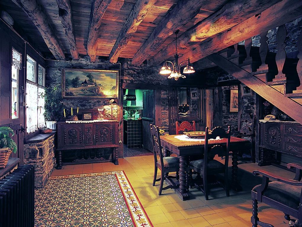Posada de RengosCasa Ponce的一间带桌椅和木制天花板的用餐室