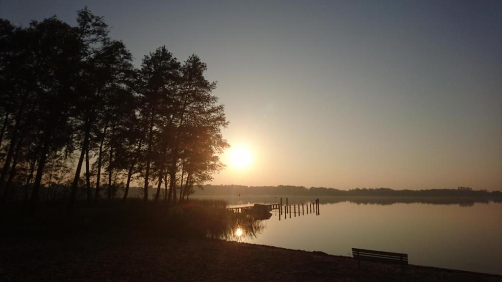文迪施里茨Fewoamglubigsee的湖面上的日落,长着长凳和树木