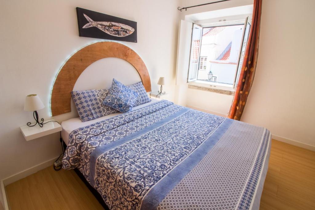 里斯本圣洛伦索公寓的一间卧室配有一张带蓝色和白色棉被的床