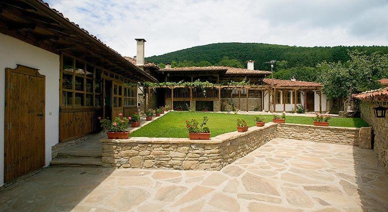 泽拉夫纳古香古藤酒店的一座带石质庭院的别墅,庭院内种植了盆栽植物