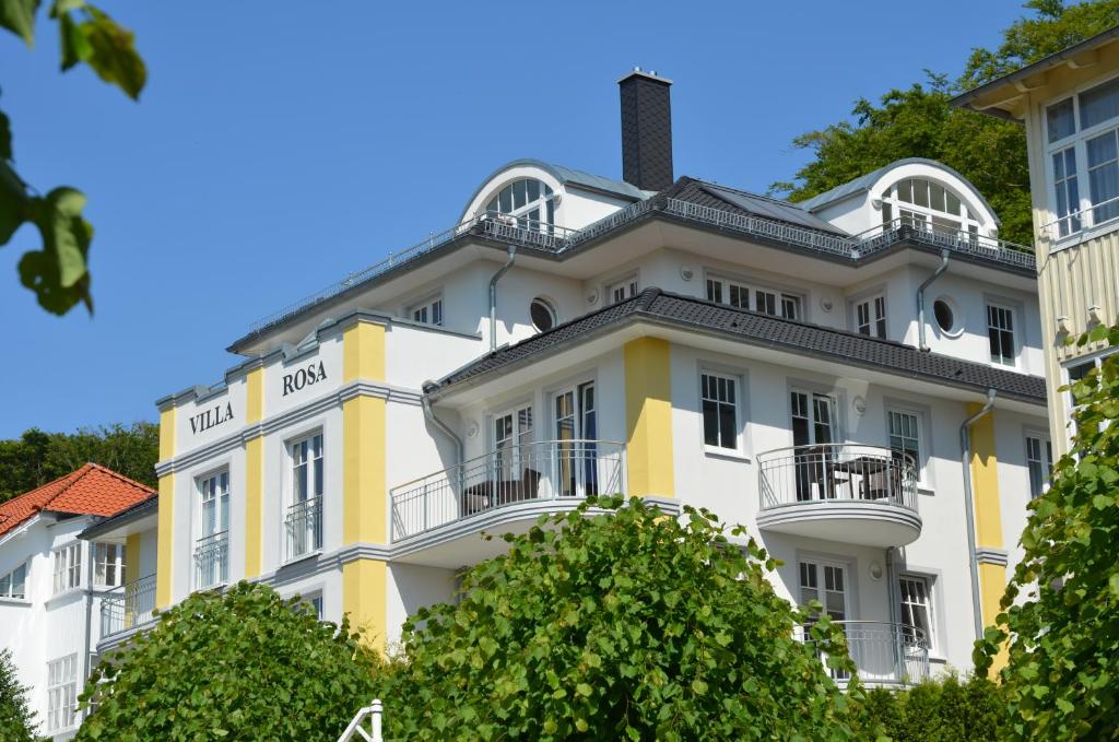 奥斯赛拜-塞林Villa Rosa - Apt. 10的一座大型的白色和黄色建筑,设有阳台