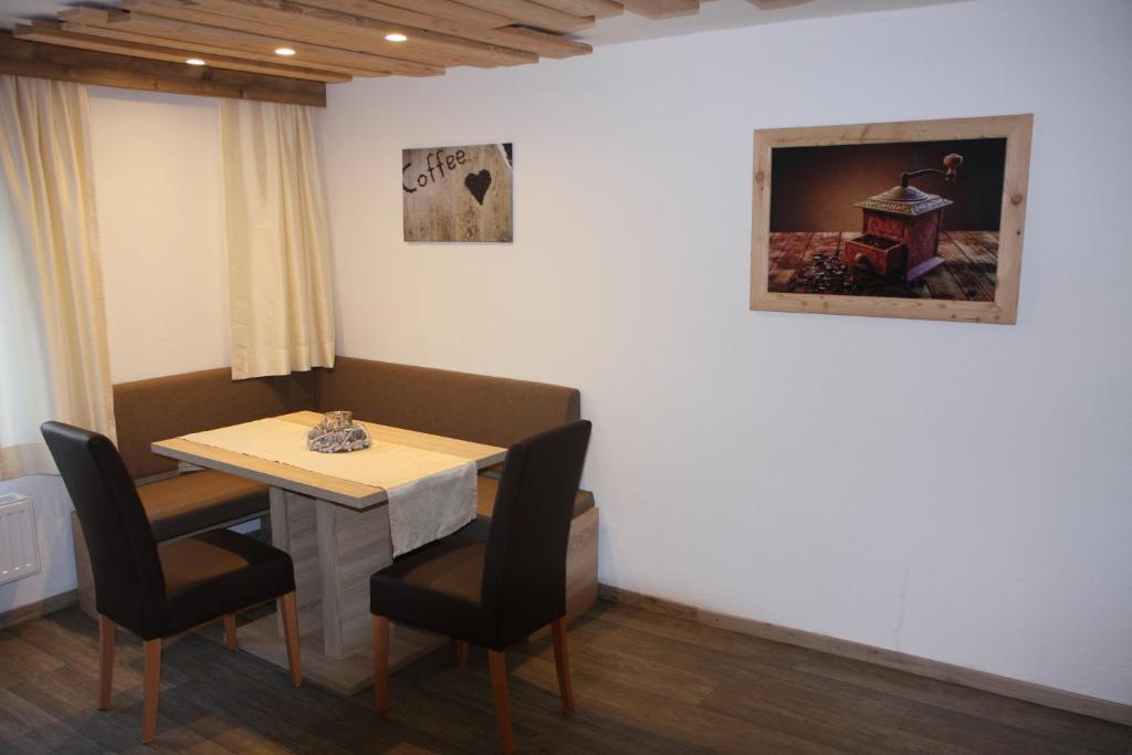 考恩台尔Haus Eckhart的一间带桌子和两把椅子的用餐室