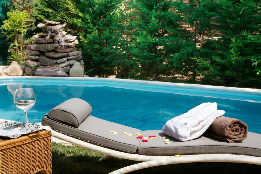 Azofra卡索纳德拉萨马斯真实度假酒店的一个带一张床和一杯葡萄酒的游泳池
