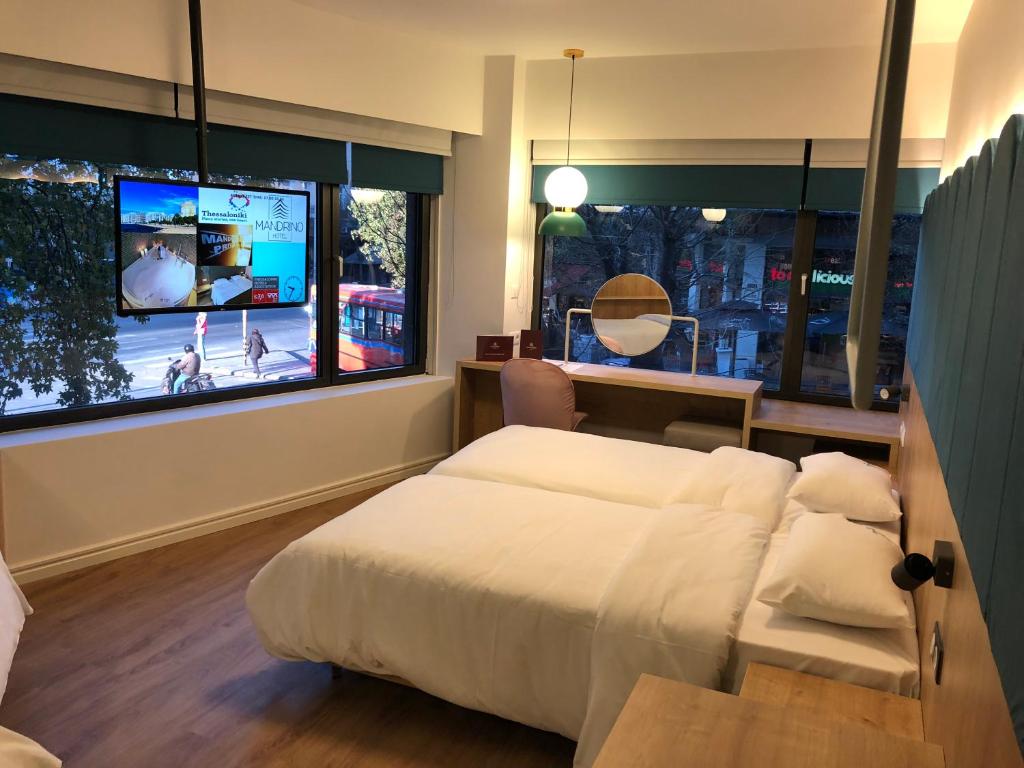 塞萨洛尼基曼德利诺酒店的一间卧室设有一张床和一个大窗户