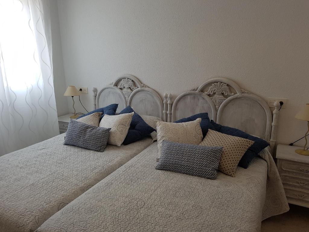 阿尔姆尼卡Apartamento centrico的一间卧室配有两张带蓝白色枕头的床