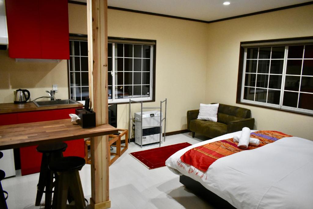饭山市高原斑尾旅馆的一间带一张床的房间和一间带桌子的厨房