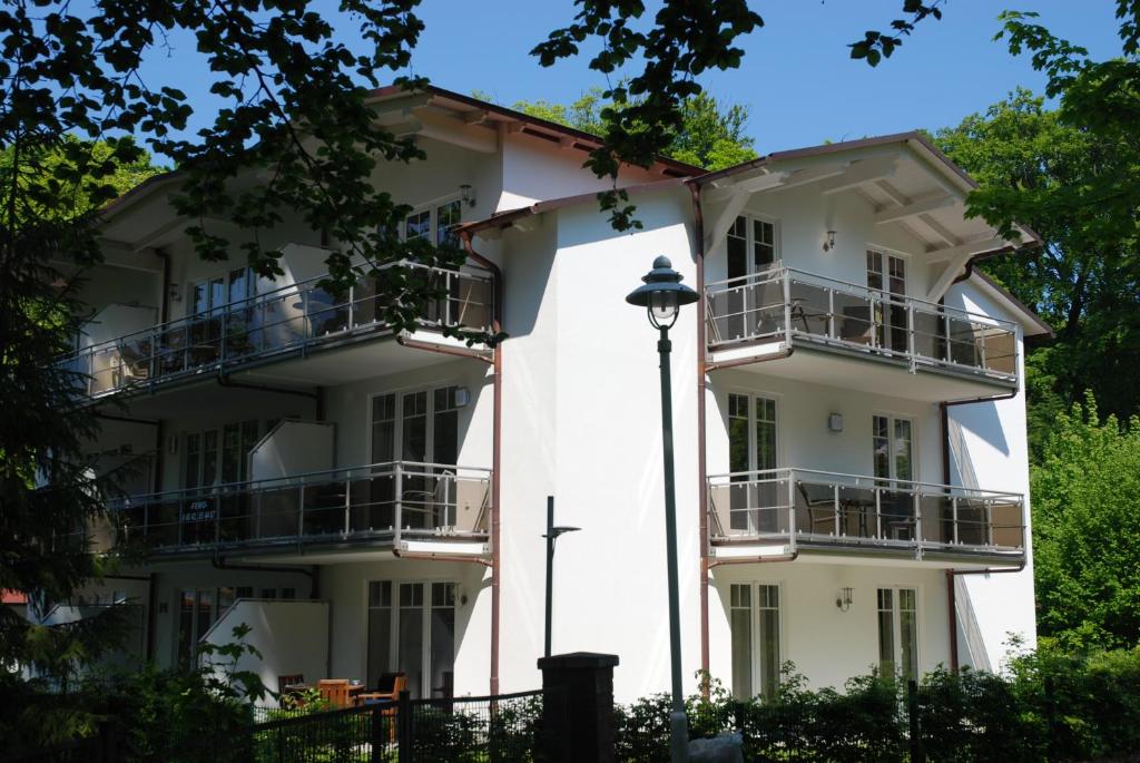 奥斯赛拜-塞林Strandwohnungen Sellin - WG04 mit 2 Balkonen的带阳台的白色建筑和街灯
