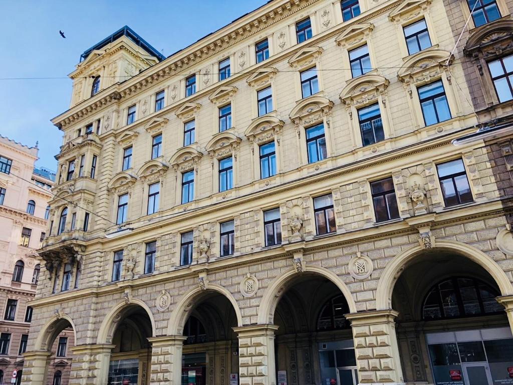 维也纳KH Apartments Universitaet的街道上一座带许多窗户的大型石头建筑