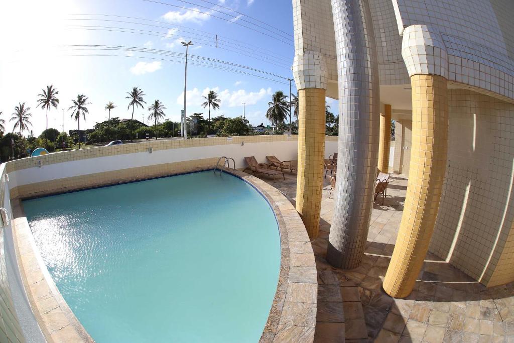 阿拉卡茹皇家海滩酒店的棕榈树建筑旁边的游泳池