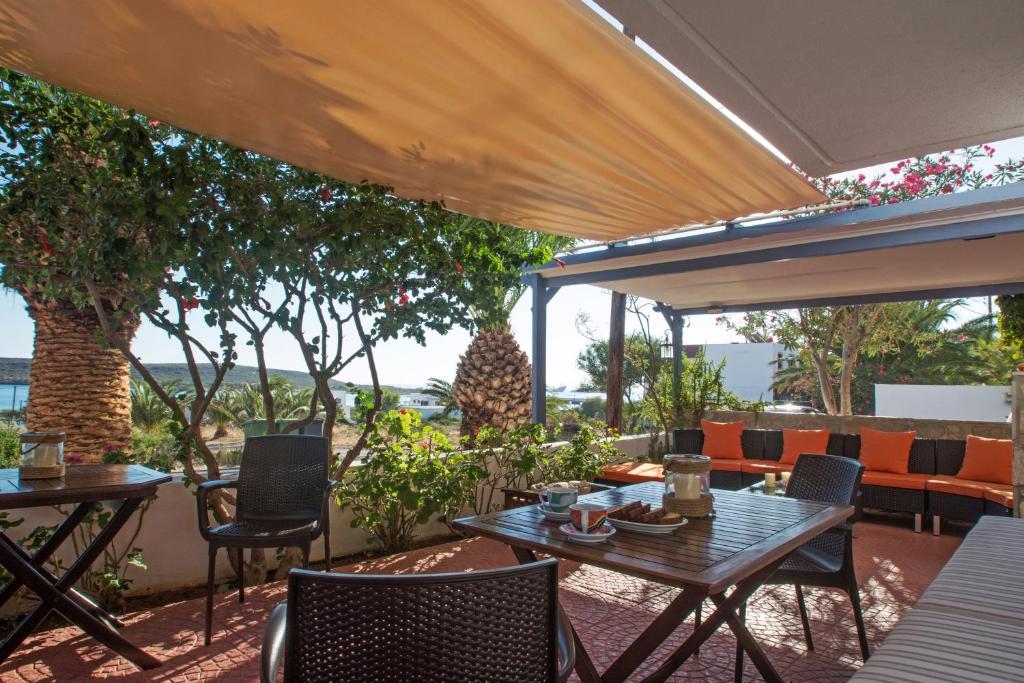 Diakofti迈斯特拉里公寓酒店的庭院配有桌椅和遮阳伞。