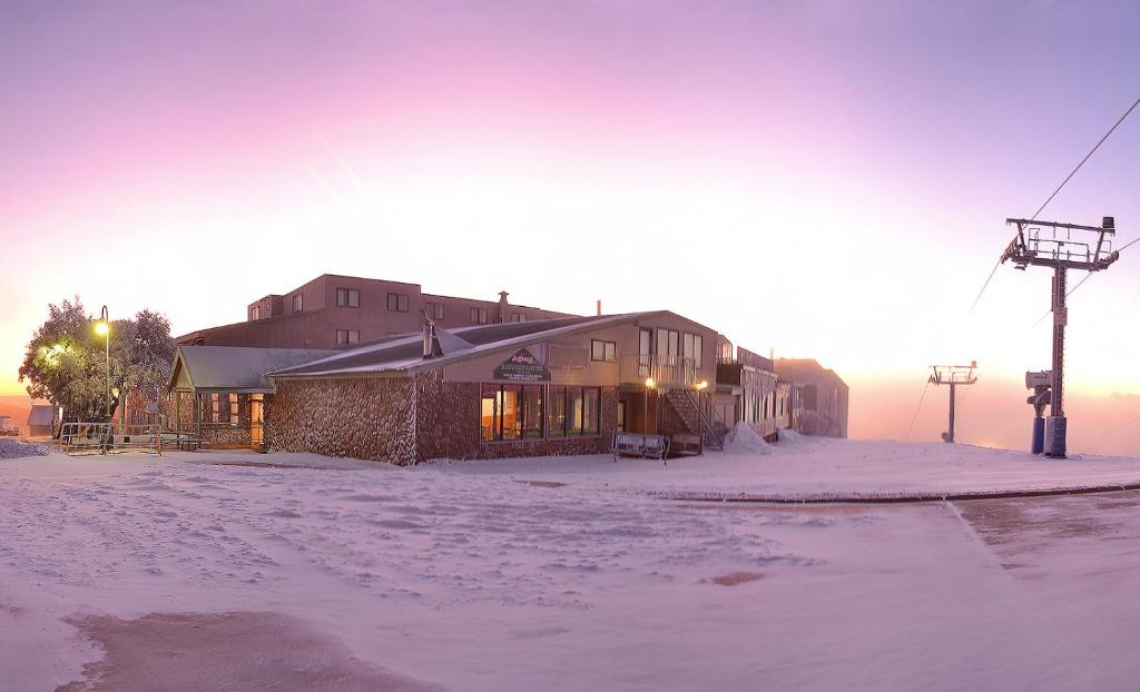 布勒山阿尔贝格山布勒酒店的雪中的一个建筑,太阳在后面