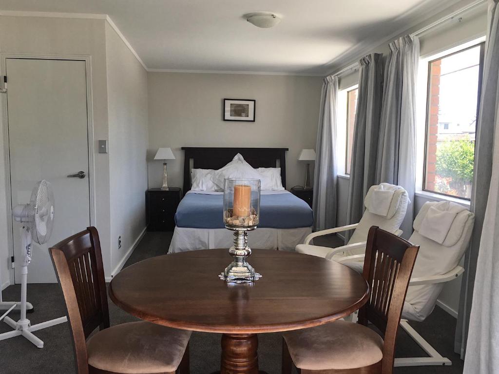 芒格努伊山Victoria Road B&B的卧室配有一张床和一张桌子及椅子