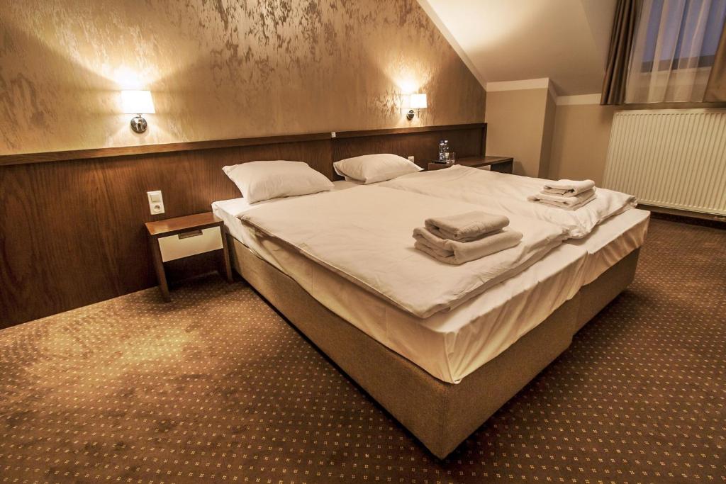 卡尔瓦里亚-泽布日多夫斯卡Hotel Tatarscy的一间卧室配有一张大床和毛巾