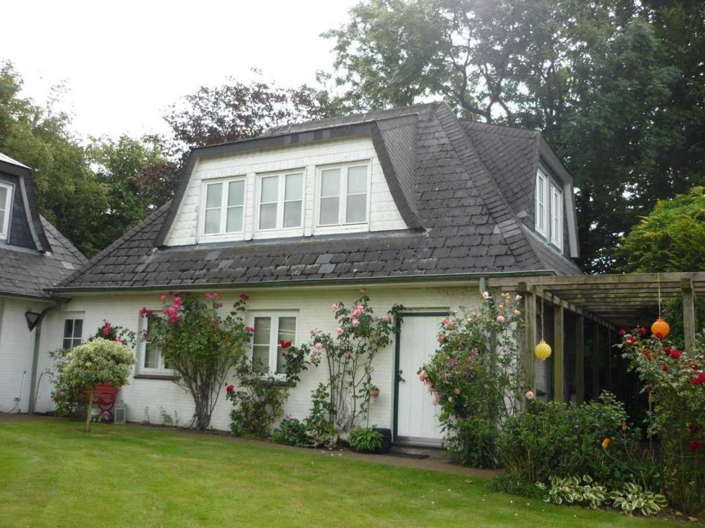 AusackerFerienwohnung Doelling的一间白色的房子,有黑色的屋顶和院子
