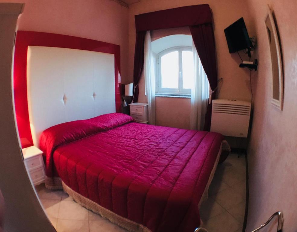 弗拉斯卡蒂艾尔伯格全景酒店的一间卧室设有红色的床和窗户。