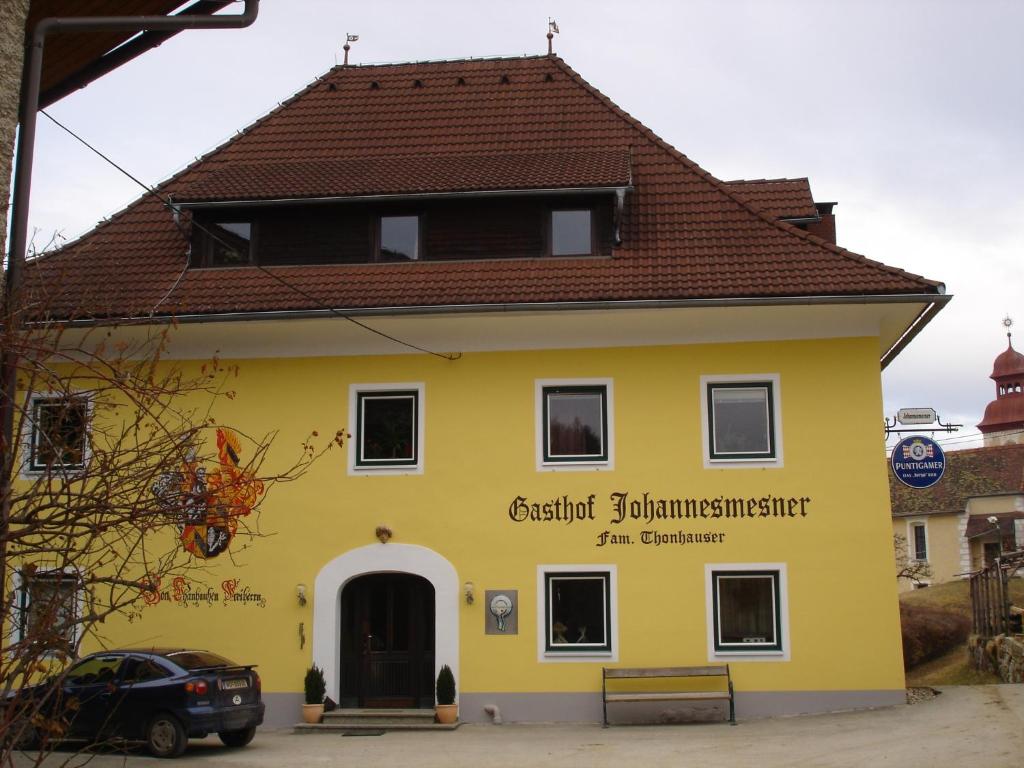 Sankt Paul im LavanttalGasthof Johannesmesner的黄色建筑,屋顶为棕色