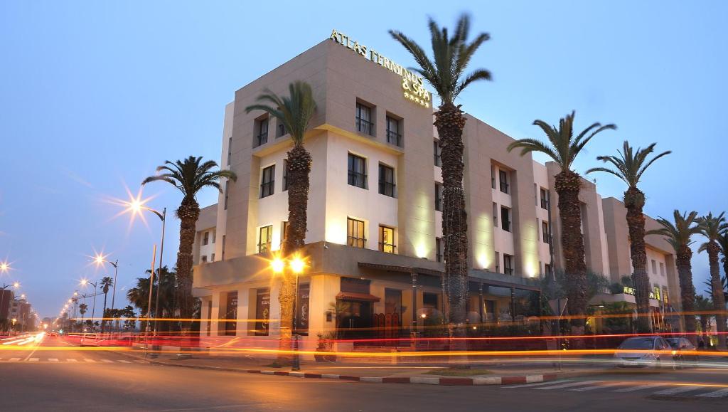 乌季达Terminus City Center Oujda的街道前方有棕榈树的建筑