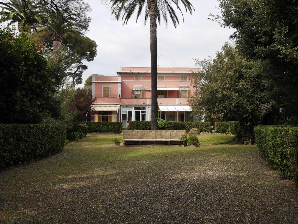 卡斯蒂利翁切洛Monolocale in villa的粉红色的建筑,有长凳和棕榈树
