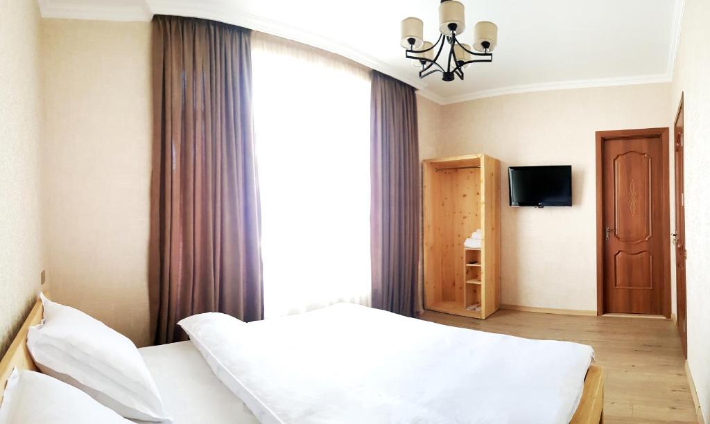 卡兹贝吉Cozy Hotel Kazbegi的卧室配有白色的床和窗户。