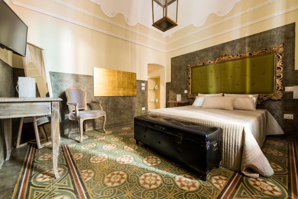 滨海波利尼亚诺Suite Minerva的卧室配有床、书桌和钢琴
