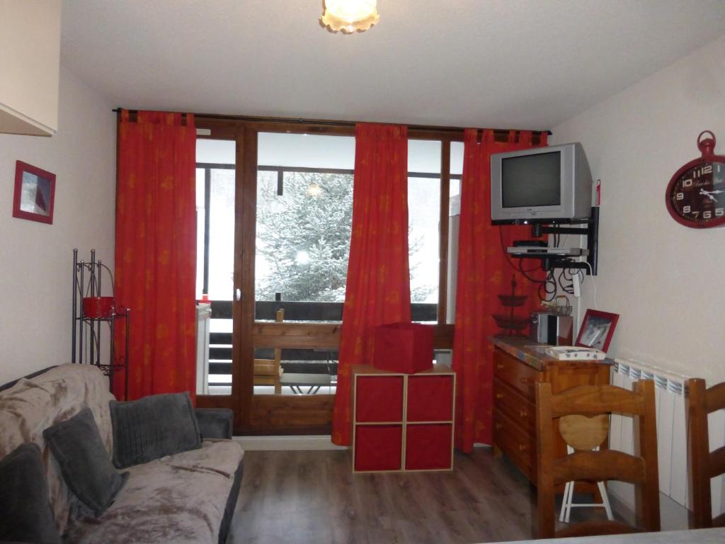勒索兹ZENITH 2015的客厅配有红色窗帘和电视