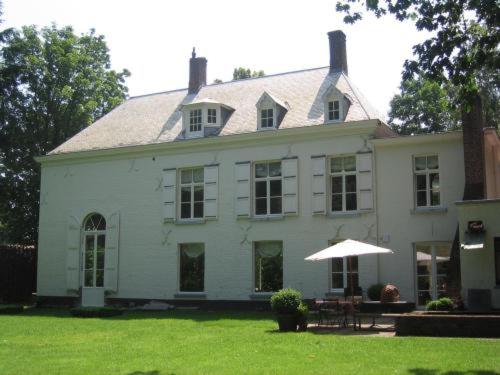 布鲁日特维胡斯布鲁日床和早餐的院子里有一把带雨伞的大型白色房子