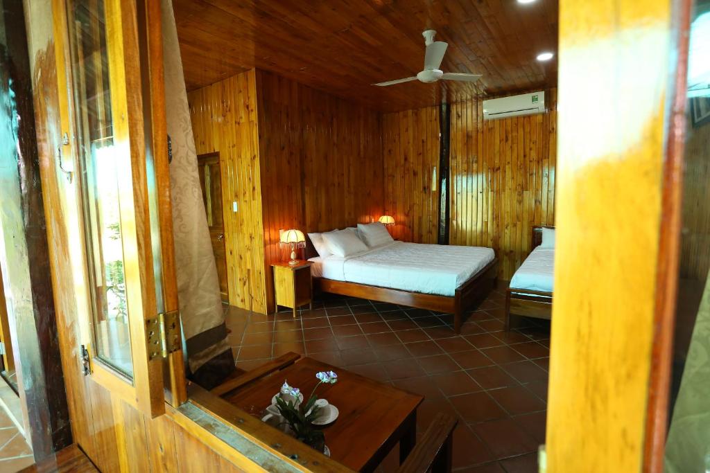 芹苴Boutique Lodge Can Tho Homestay的卧室配有一张床铺,位于带木墙的房间内