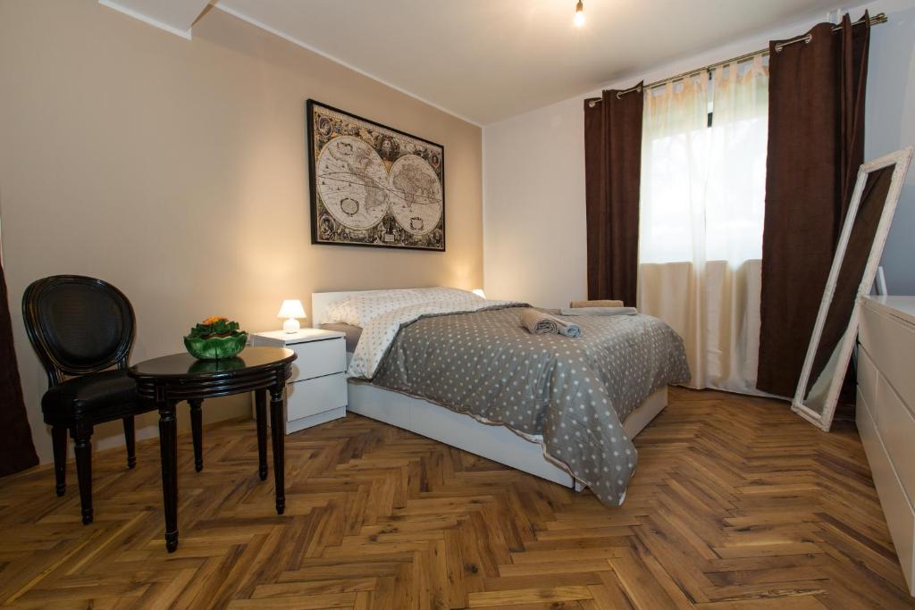 卢布尔雅那New rooms & apartments in Ljubljana的卧室配有1张床、1张桌子和1把椅子