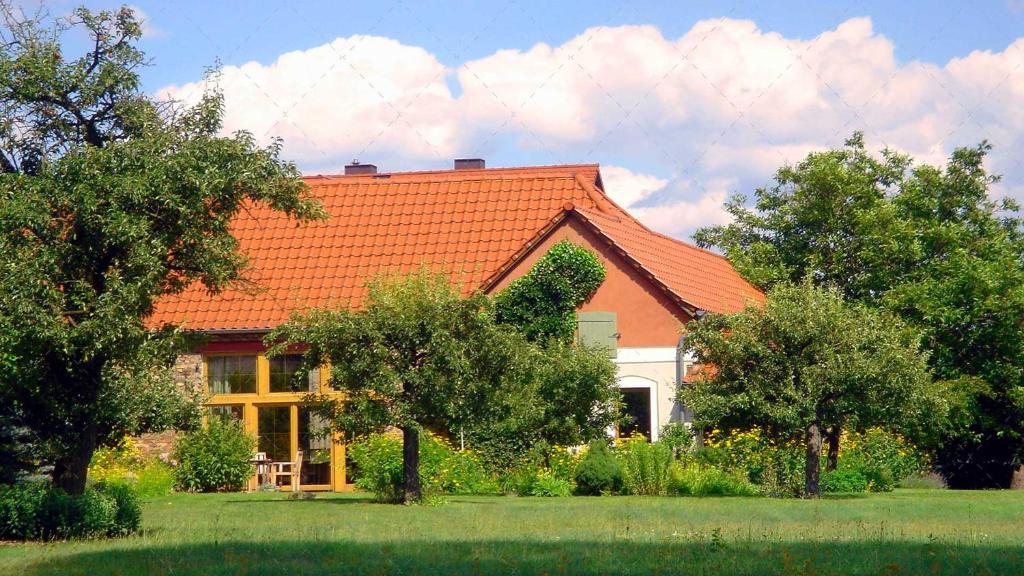 Neu LübbenauJANISCHs Fewo im Spreewald的一座拥有橙色屋顶和一些树木的房子