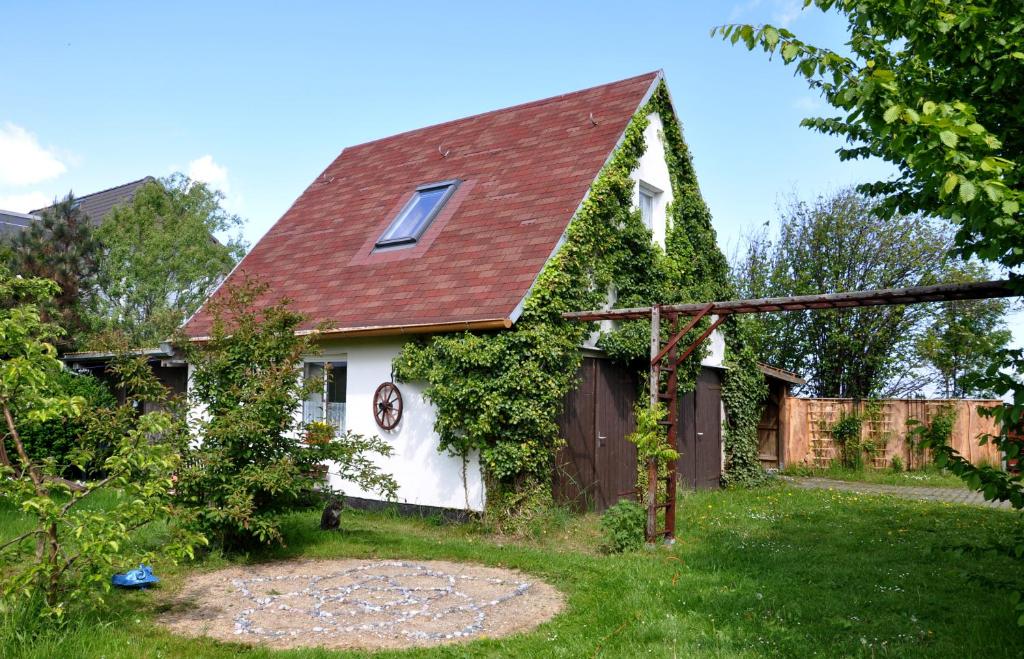奥斯特巴特宁哈根Sommerferienhaus的一间白色的小房子,有红色的屋顶