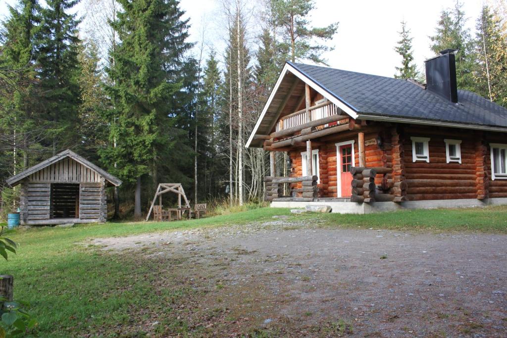VarpaisjärviMäkitorppa的树林中的小木屋,带院子