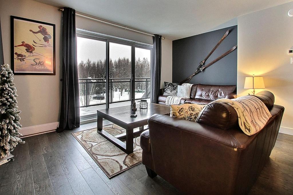 博普雷INITIAL - OLYMPIQUE - Mont-Sainte-Anne的客厅配有沙发和桌子