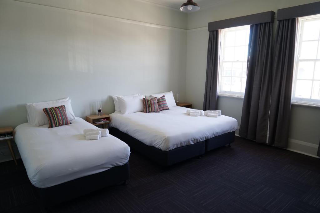 悉尼玫瑰山酒店 的带2扇窗户的客房内的2张床