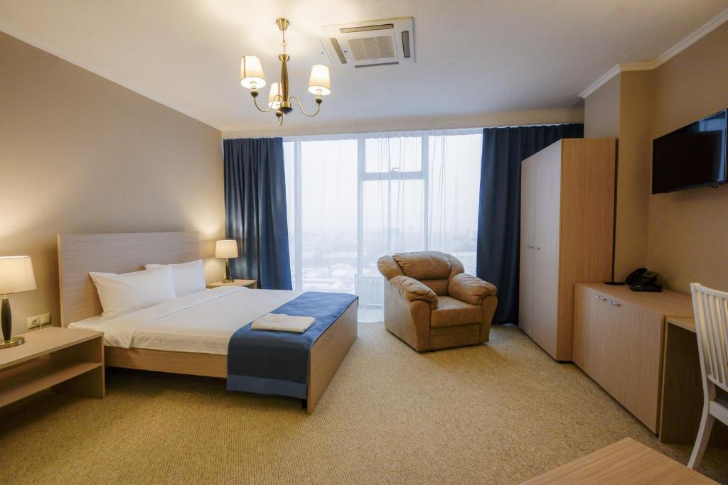 沃罗涅什Zastava Hotel的酒店的客房 - 带一张床、椅子和窗户
