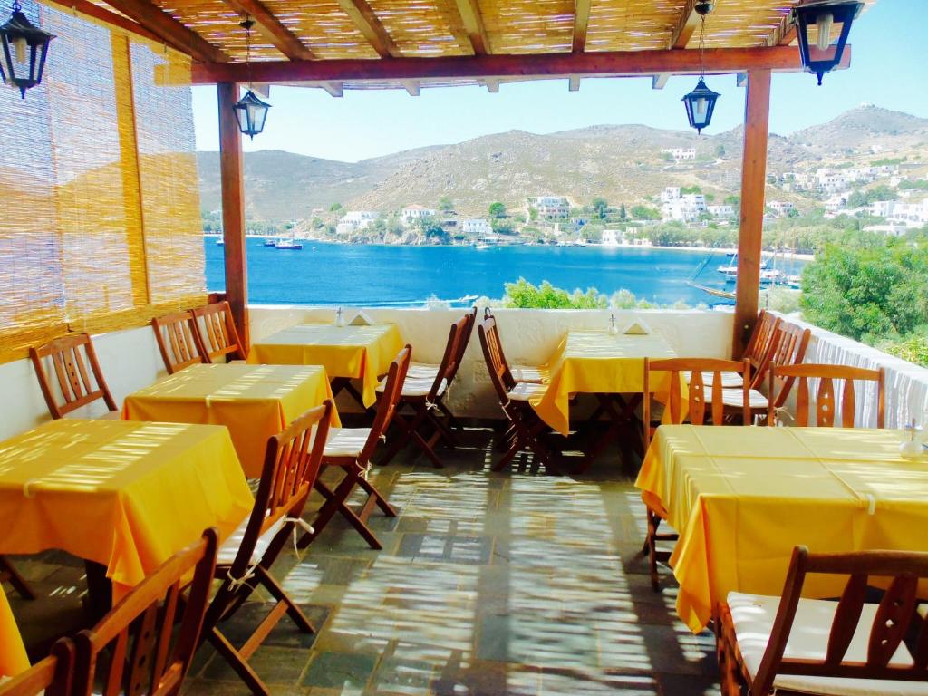 GrikosAlexandros Hotel的一间设有桌椅并享有水景的餐厅