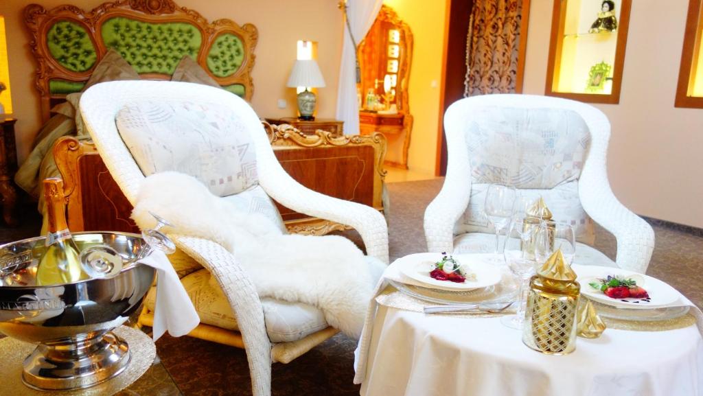 考纳斯帕匝里斯公园酒店的两把白色的椅子和一张桌子,上面有食物