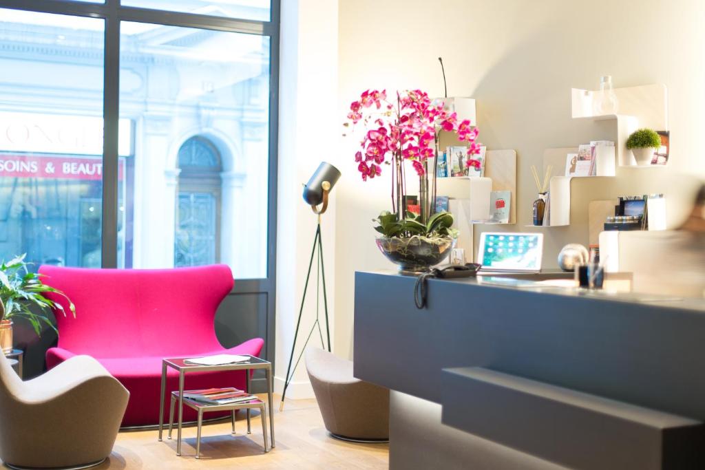 洛桑旅客精品酒店的一个带粉红色椅子和一张书桌的办公室