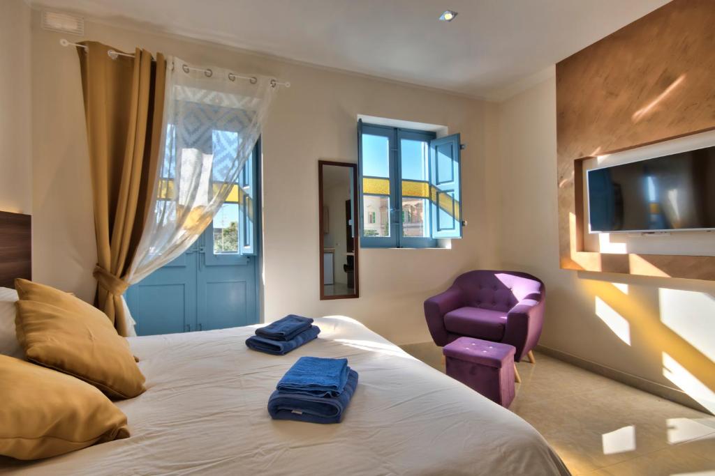 圣朱利安斯Central Suites St. Julian's的一间卧室配有一张带2条蓝色毛巾的床